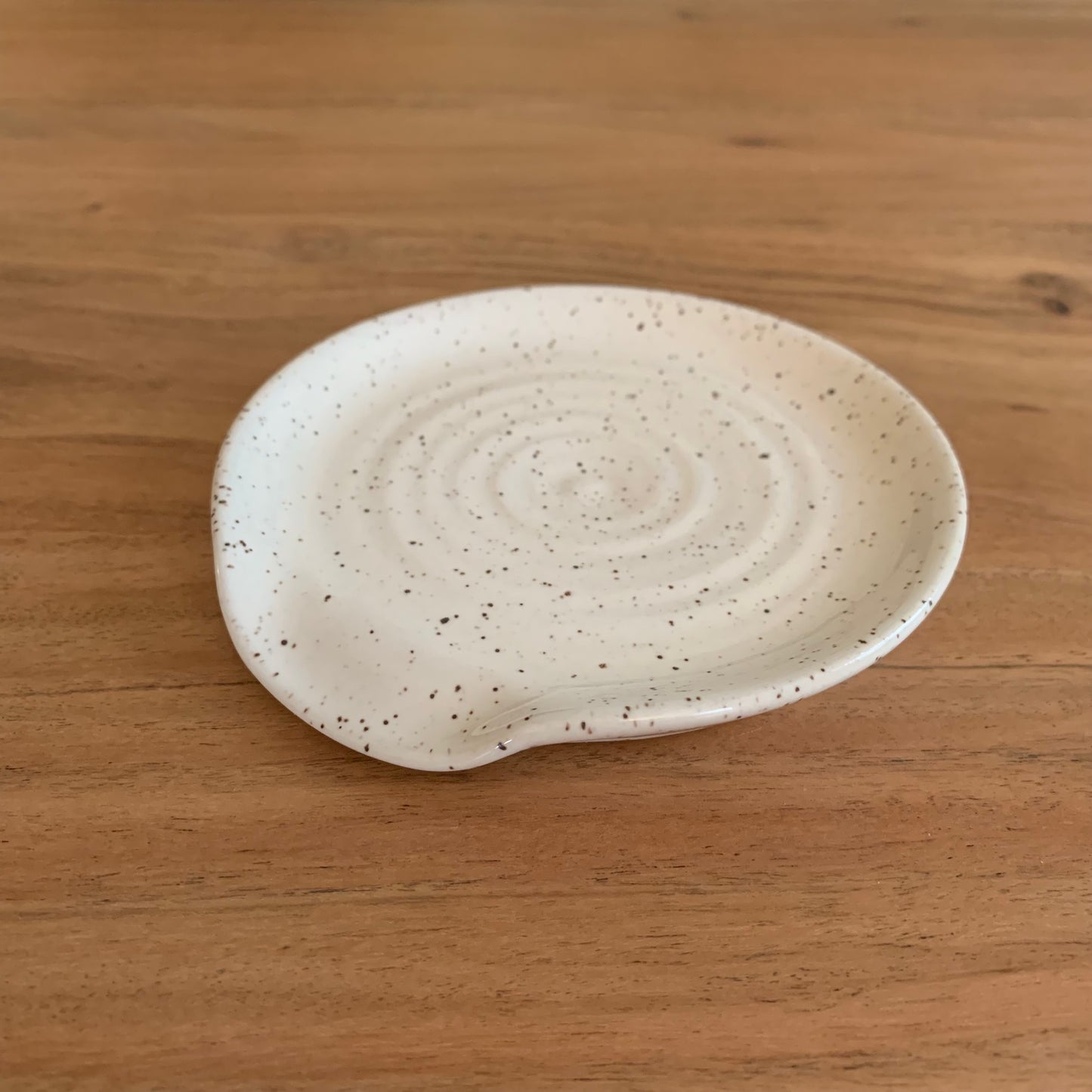 ceramic white speckle spoon rest in a glossy finish. Approx 4.5" in width