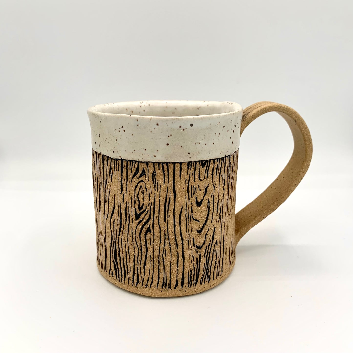 Pottery wood grain mug - a stunning and detailed wood grain design wraps around the body of the natural brown speckle pottery mug. The rim is glazed in a soft white matte glaze. Holds 14 oz